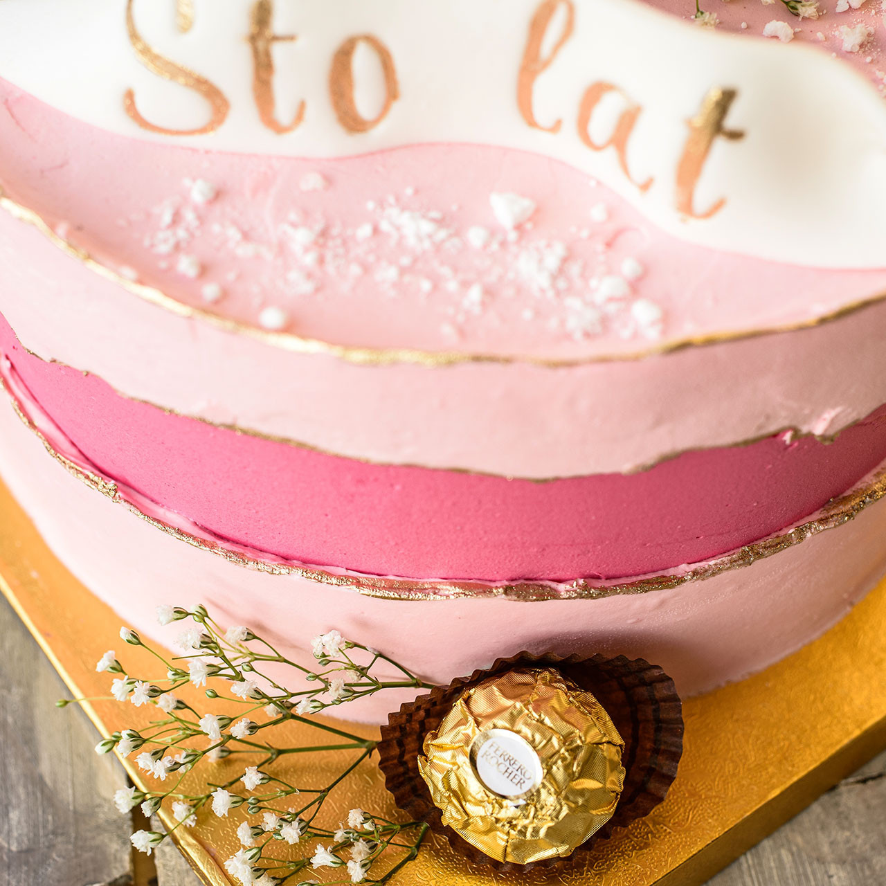 Tort fault line cake różowy z kwiatami i napisem